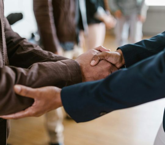 Close-up of two businesspeople shaking hands, symbolizing agreement and partnership.